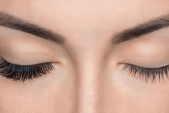 Eyelash removal procedure close up. Beautiful Woman with long lashes in a beauty salon. Eyelash extension.