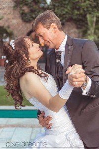 Das Brautpaar tanzt im Gutshof während der Hochzeitsfotograf sie dabei fotografiert.