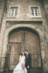 Hochzeitsfotografie vor dem Gutshof der Kommandeursburg in Kerpen Blatzheim. Braut und Bräutigam schmusen.