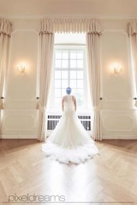 braut steht vor dem fenster im schloss dyck und schaut in die ferne