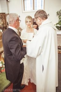 Kirchliche Trauung in der St. Antonius Kirche Swisttal. Hochzeitsfotograf hält den Moment des Gelübtes fest.