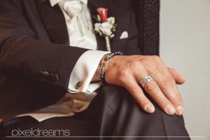 Bräutigam sitzt und wartet auf die Braut. Sein außergewöhnlicher Trauring steht im Focus- Hochzeitsfotos vom Hochzeitsfotografen Pixeldreams