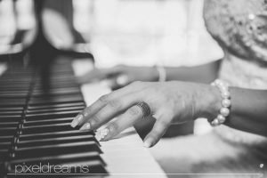 Braut spielt Klavier man sieht ihren Trauring, Hochzeitsfotograf macht Hochtzeitsfotos