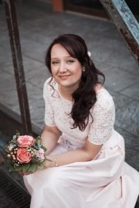 Hochzeitsbild spontan entstanden. Braut sitzt in einem Innenhof der Kölner Altstadt. Natürliches Hochzeitsfoto einer Braut fotografiert vom Hochzeitsfotografen Pixeldreams