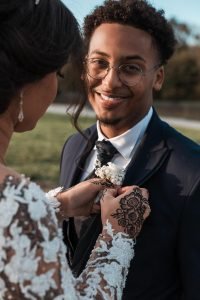 Hochzeitsfotograf Bruehl Schloesser - somalisch afrikanisch hochzeit - Hochzeitsreportage_6_Brautpaar-Shooting-Braut steht Bräutigam die Ansteckblume an
